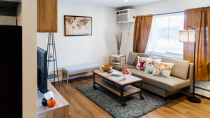 A modern living room with a sofa, coffee table, and a world map artwork.