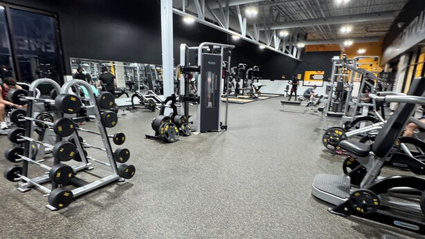 A gym with various exercise equipment, including weight machines and dumbbells.