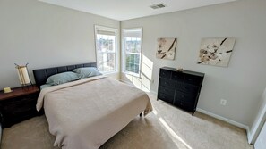A bedroom with a bed, dresser, and artwork on the wall. - Charming 4-bedroom house in Woodstock perfect for your getaway (Woodstock)