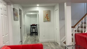 Una sala de estar moderna con un sofá rojo, una mesa de centro de vidrio y una escalera.