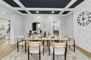 Een eethoek met een rechthoekige tafel voor zes personen, omringd door zes stoelen met gestoffeerde zitplaatsen en houten frames.