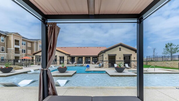 Area piscina con lettini e una zona relax coperta.