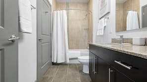 Une salle de bain moderne équipée d’une douche, de toilettes et d’un lavabo.
