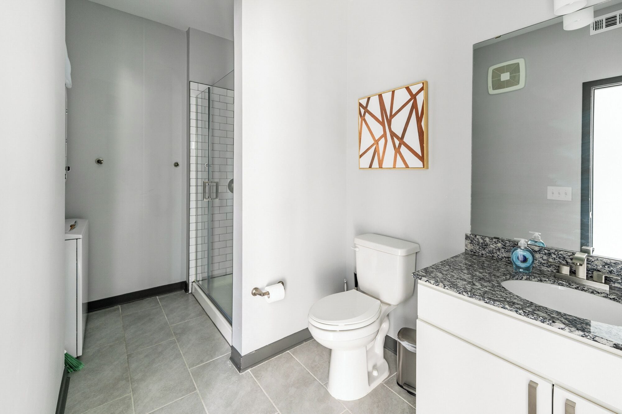 Un bagno moderno con doccia, toilette e lavandino.
