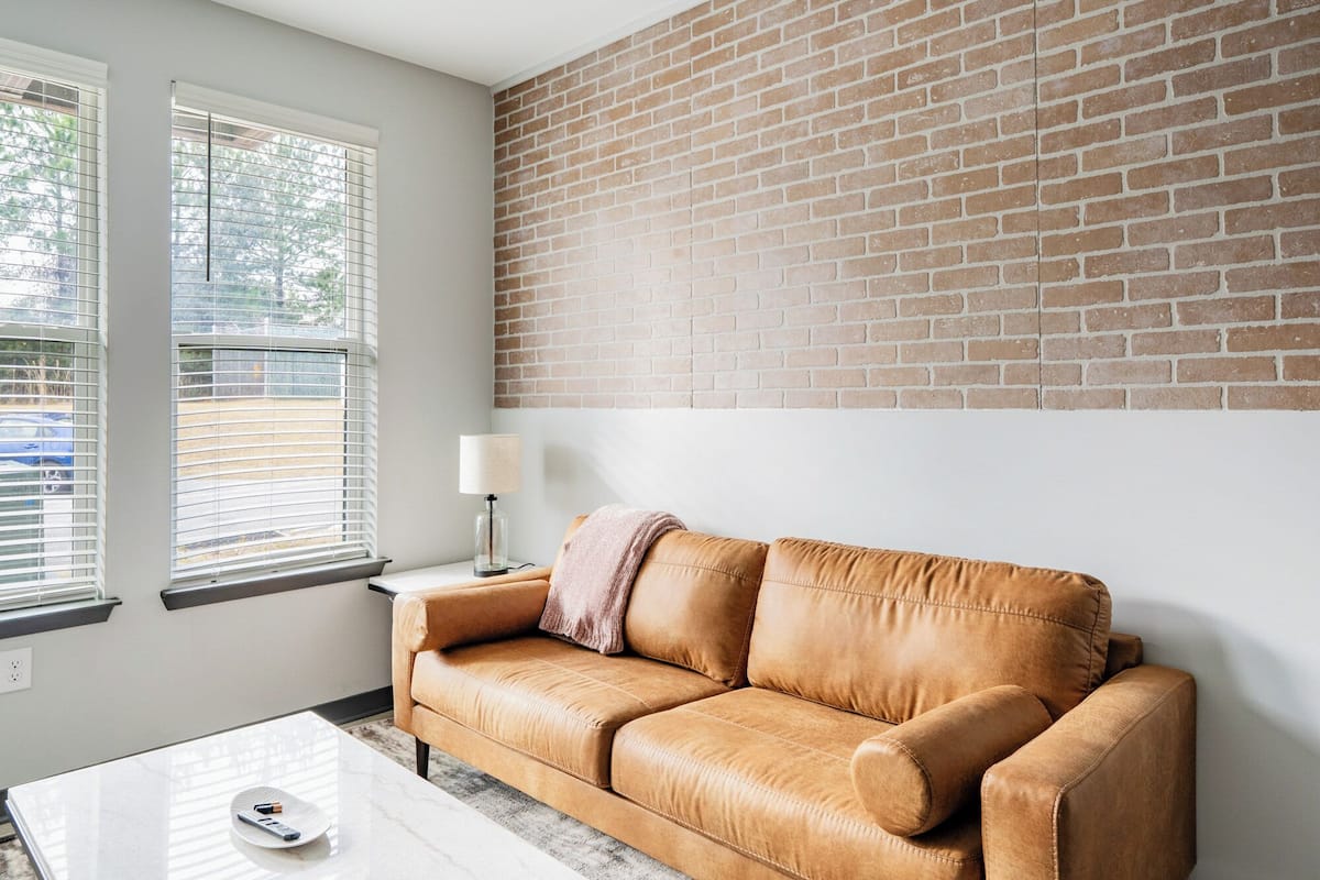 A living room with a leather sofa, a coffee table, and a lamp.