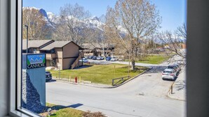En vy över Sunset Resorts Canmore med en parkeringsplats, en byggnad med en skylt och berg i bakgrunden.