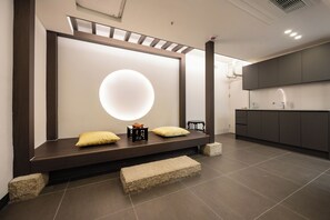 Een moderne badkamer met een grote spiegel, een zitbankje en een minimalistisch design.