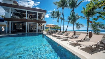 Una piscina al aire libre, camas de piscina gratis, sombrillas