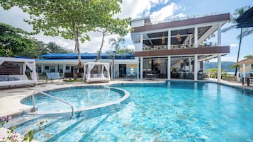 Una piscina al aire libre, camas de piscina gratis, sombrillas