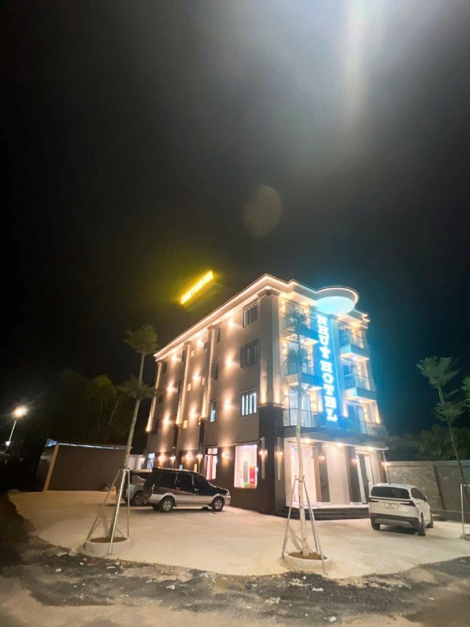 Een meerlaags hotel met verlichte signage en een goed verlichte gevel.