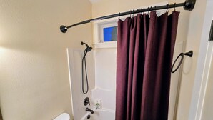 Un bagno con vasca, WC e tenda da doccia.