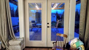 Una stanza con una porta scorrevole in vetro che si apre su un patio esterno.