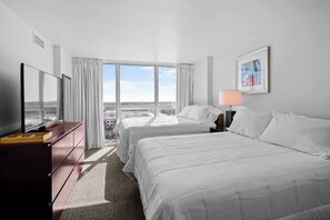 A hotel room with two beds, a TV, a desk, and a window with a city view. - Modern Cozy Apartment Downtown Fort Myers (Fort Myers)
