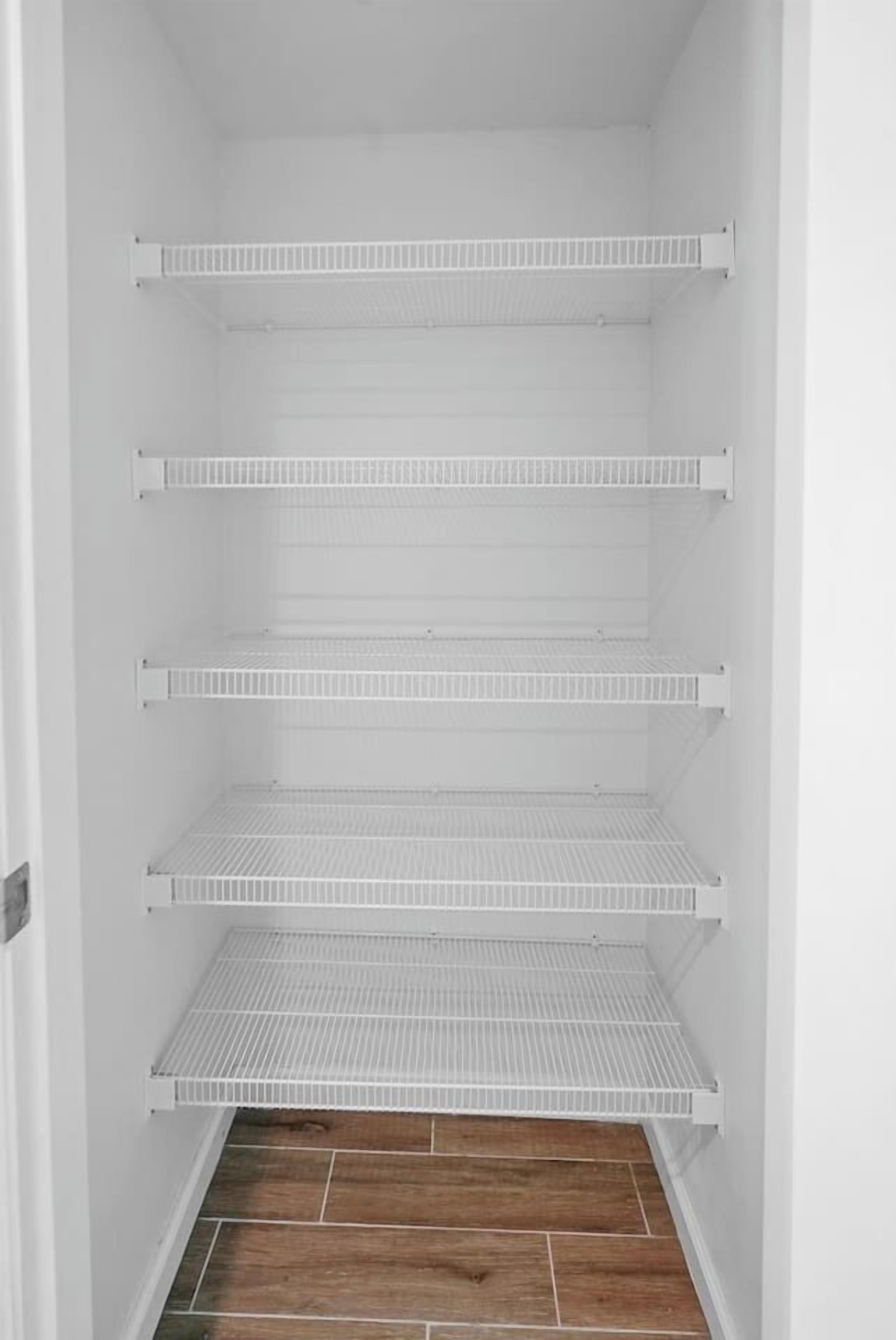 Ein heller Innenraum mit vier weißen Regalen.