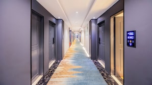 A hotel hallway with a long, carpeted corridor, doors on both sides, and a digital lock display on the right wall. - Andy International Hotel Shenzhen (Shenzhen)