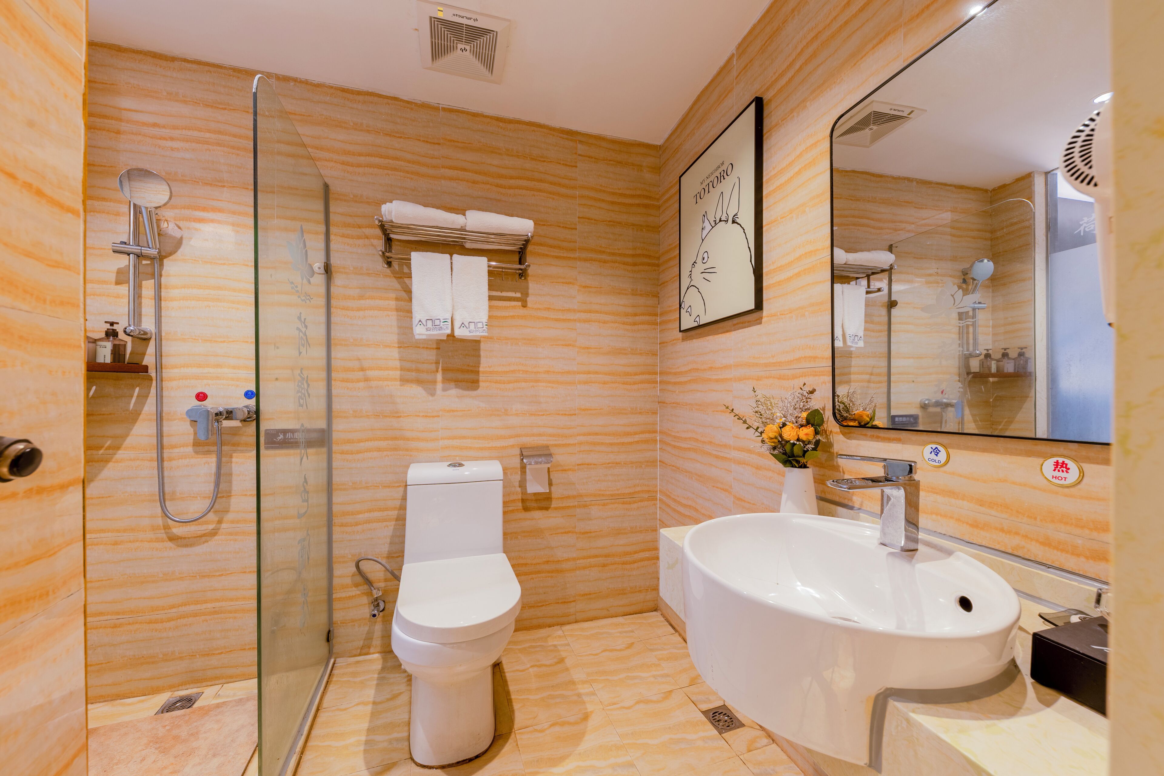 Un baño moderno con ducha de vidrio, inodoro y lavamanos amplio.