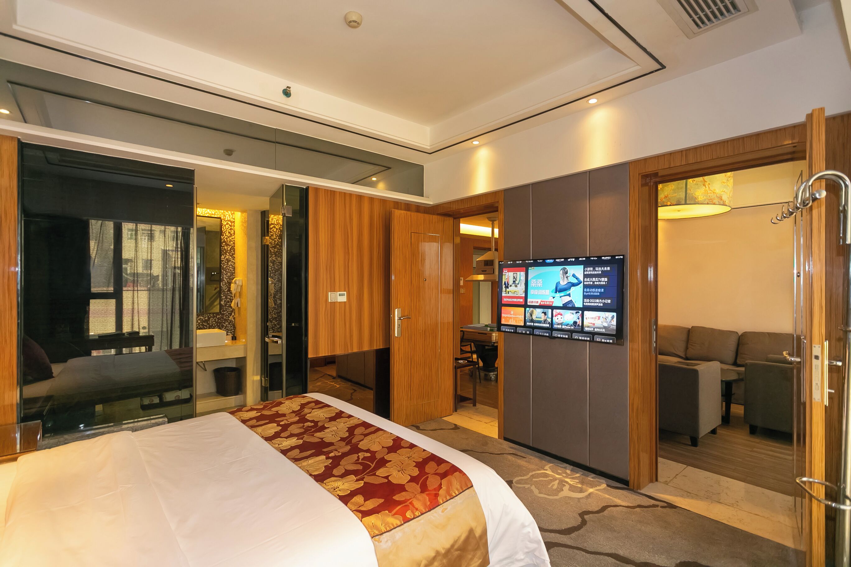 Een hotelkamer met een groot bed, een televisie, een bureau en een zithoek.