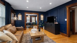 A modern living room with a leather sofa, a wooden coffee table, and a TV on a black cabinet. - Prestigious Milton Designer Home (Milton)