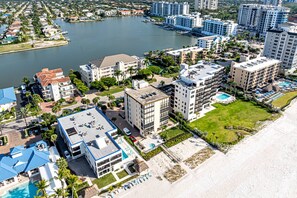 A coastal hotel with multiple buildings, a swimming pool, and a beach area. - Admiralty on Gulf Shore Dr. - 6th flr Beachfront Penthouse - Amazing Gulf views & Stunning Sunsets (Naples)