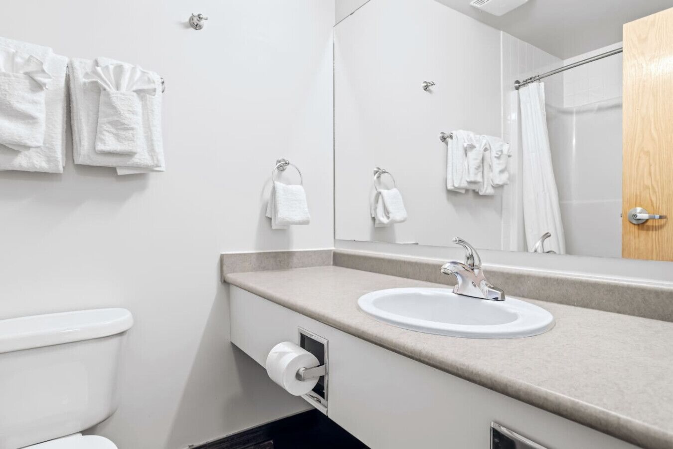 A modern bathroom with a white sink, a toilet, and a shower area.