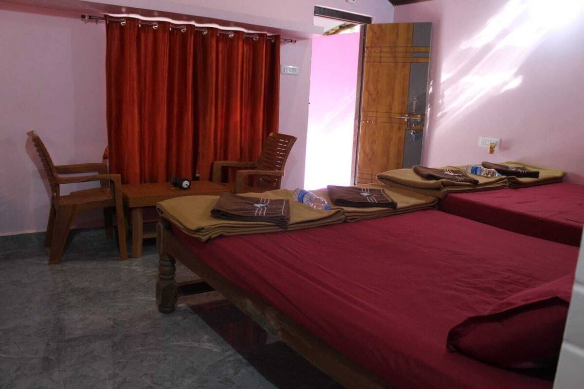 A bedroom with two beds, a desk, and a chair.
