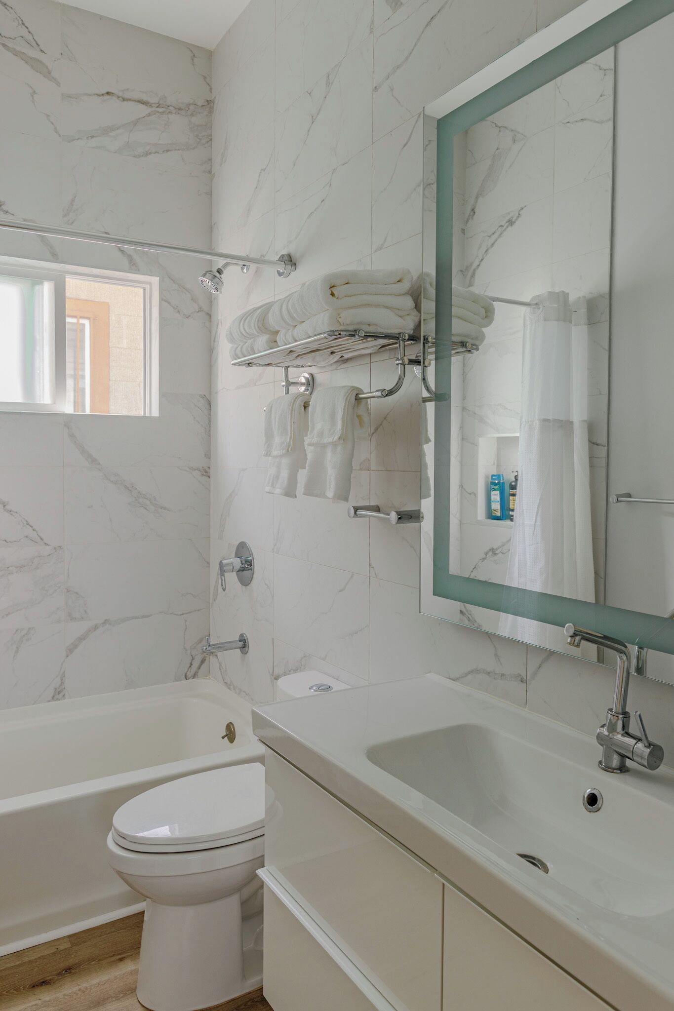 A bathroom with a bathtub, toilet, and a sink with a mirror.