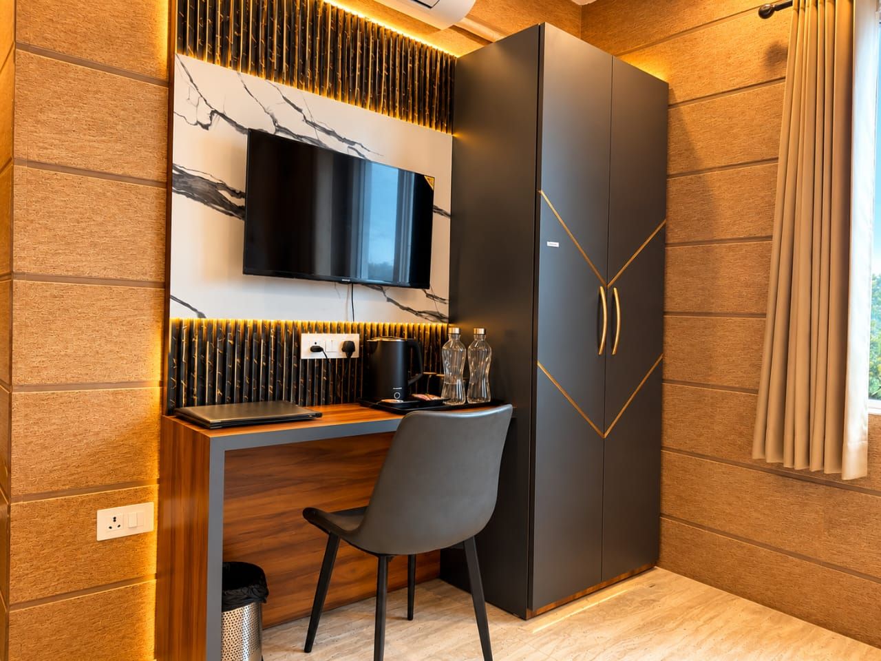 Una habitación moderna con escritorio integrado, televisión de pantalla plana y armario con diseño geométrico.