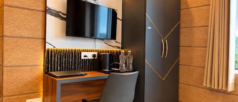 A modern room with a built-in desk, a flat-screen TV, and a wardrobe with a geometric design.