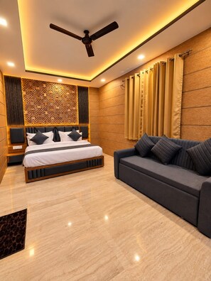 Une chambre moderne avec un lit, un canapé, un ventilateur de plafond et un panneau décoratif mural.