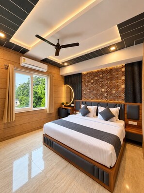 Une chambre moderne avec un grand lit, un ventilateur de plafond et un panneau décoratif mural.