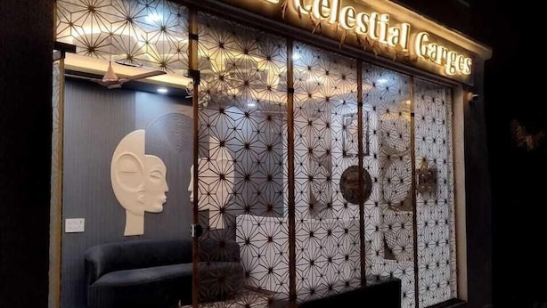A hotel named 'Hotel Celestial Gorges' with a modern design, featuring a large illuminated sign, geometric patterned windows, and a visible interior with a sofa and decorative elements. - Hotel Celestial Ganges (Rishikesh)