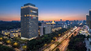 A high-rise building with illuminated windows and a prominent sign. - ECHENG Hotel (Nanning Mixc City Exhibition Branch) (Nanning)
