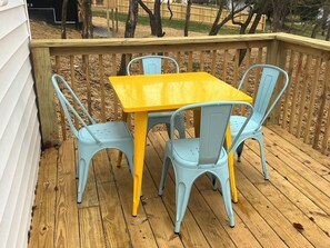 A wooden deck with a yellow table and four light blue chairs. - The Swift Lake House (Somerset)