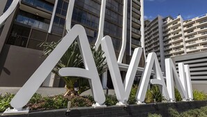A modern building with large white letters spelling "AVAN" in the foreground, surrounded by greenery. - Broadbeach Stunner Modern and Central w/free parking (Broadbeach)