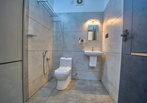 A modern bathroom with a toilet, sink, and shower. - De Waves (Varkala)