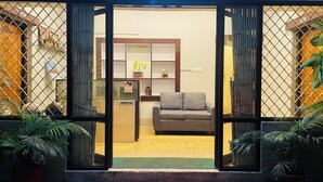 A reception area with a sofa, a reception desk, and a potted plant. - Venus Heritage (Bhubaneshwar)