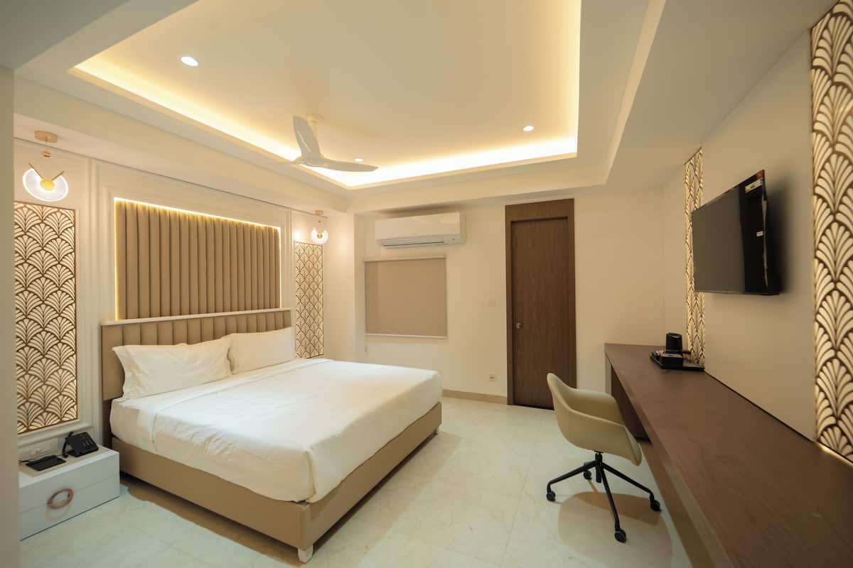 Une chambre moderne équipée d’un lit, d’un bureau, d’une chaise et d’un système de climatisation intégré.