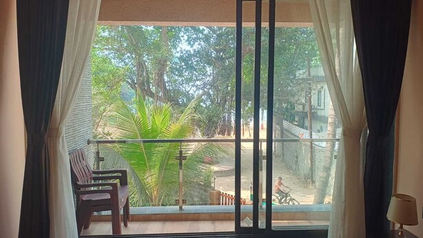 Una habitación con un ventanal grande, una silla y una mesa.