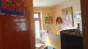 Et receptionsområde med en trædør, et skilt der siger "RECEPTION", og en disk med forskellige genstande.