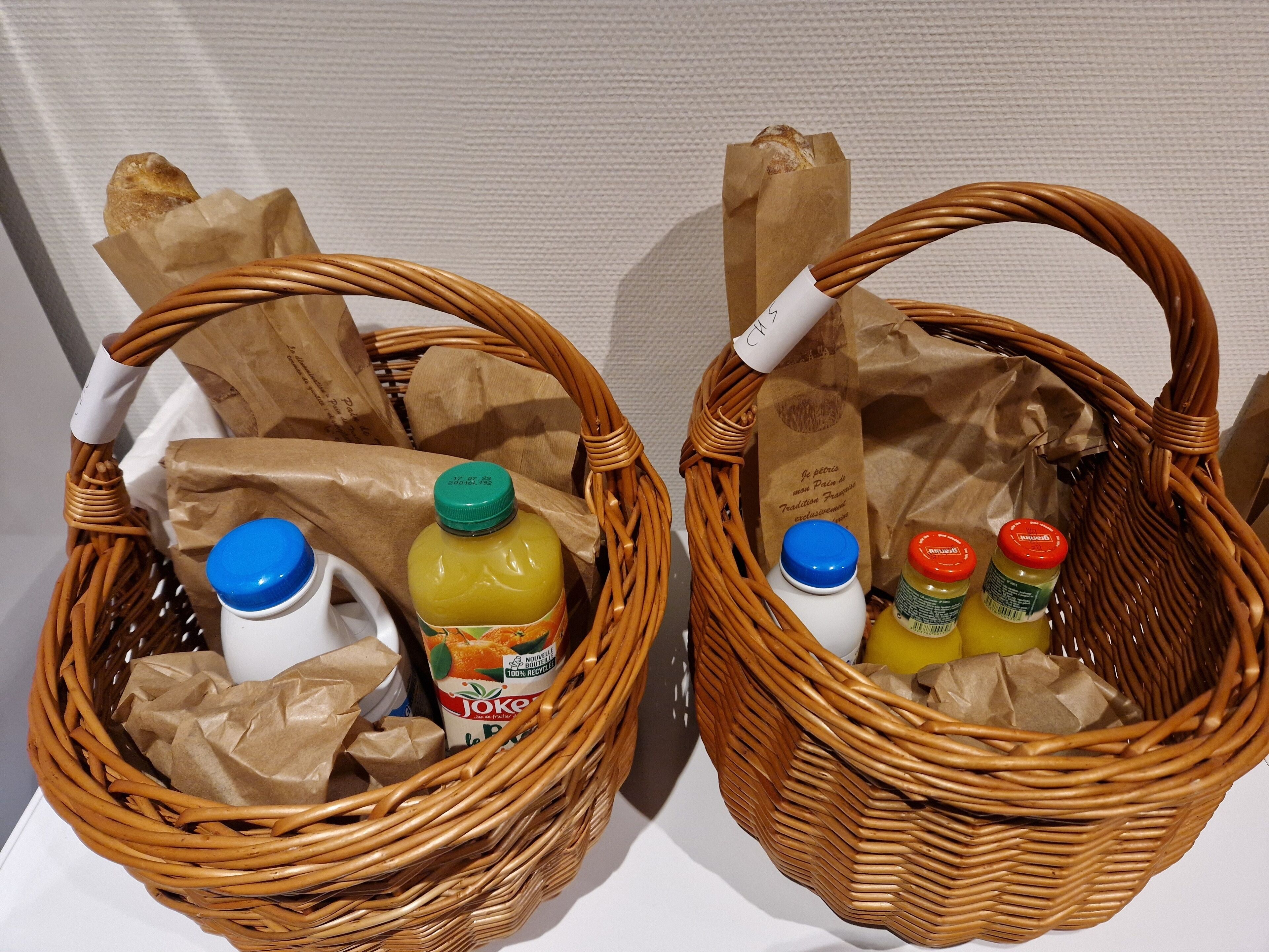 Two wicker baskets containing various items including bottles and paper bags.