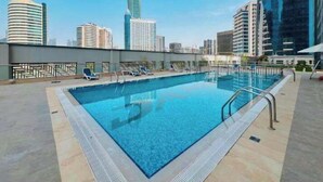 Una piscina en la azotea con un horizonte urbano de fondo.