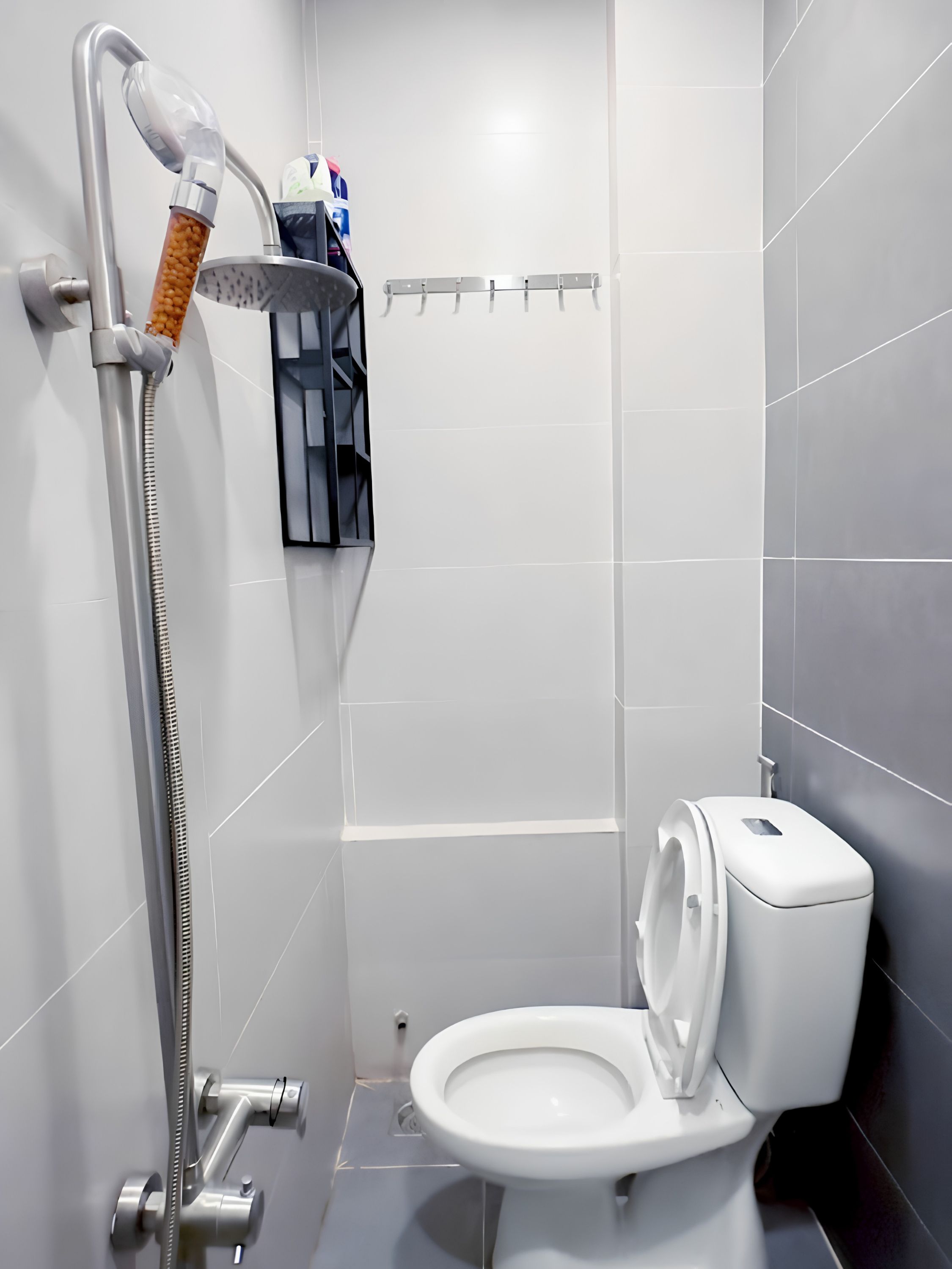 Une salle de bain moderne équipée d’une douche, de toilettes et d’un porte-serviettes.