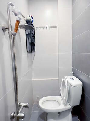 Un baño moderno con ducha, inodoro y perchero.