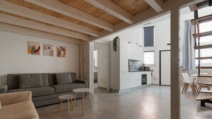 A modern living room with a sofa, a small round table, and artwork on the wall. - GuestHost - A comfortable and welcoming 56 square meters studio apartment, perfect for five people, located on the ground floor of a building with a private entrance.The property is located in the Affori neighborhood, an area full of amenities, including (Milan)