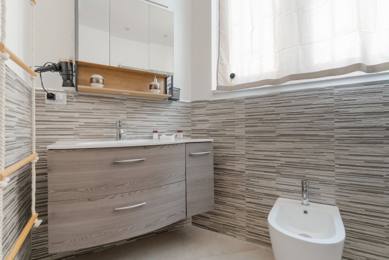 Ein modernes Badezimmer mit einem Holzwaschtisch, einem Bidet und einem Spiegel über dem Waschtisch.