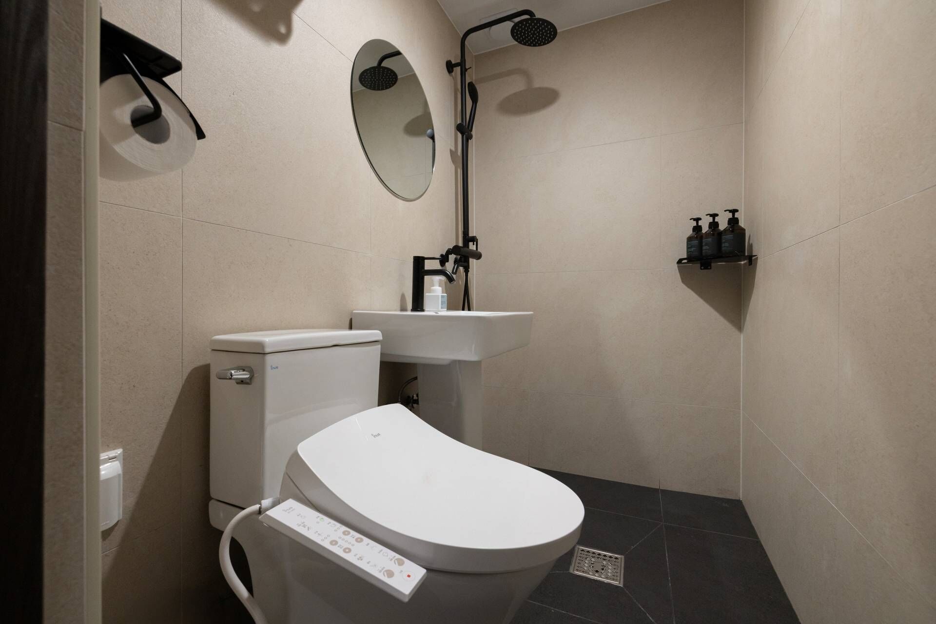Ein modernes Badezimmer mit Toilette, Waschbecken, Spiegel und Dusche.