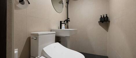 Ein modernes Badezimmer mit Toilette, Waschbecken, Spiegel und Dusche.