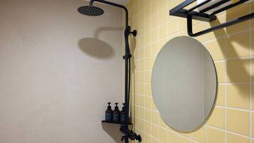 A bathroom with a shower, a towel rack, and a mirror.