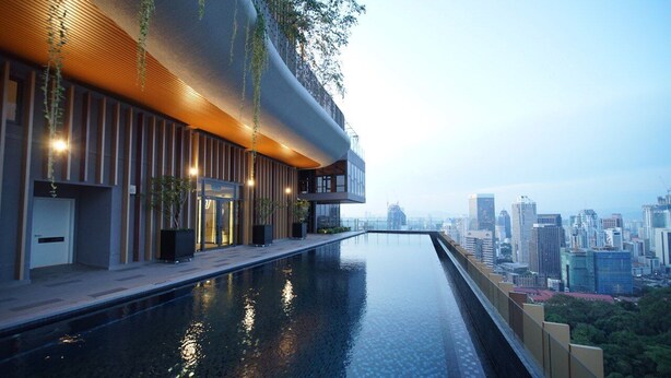 A modern building with a long, narrow pool and a city view. - Ceylonz Suites by Mana Mana (Kuala Lumpur)
