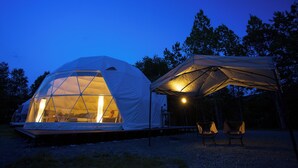 A geodesic dome tent with a covered patio area, two chairs, and a small table. - Gramping Stay Tomamu (Shimukappu)